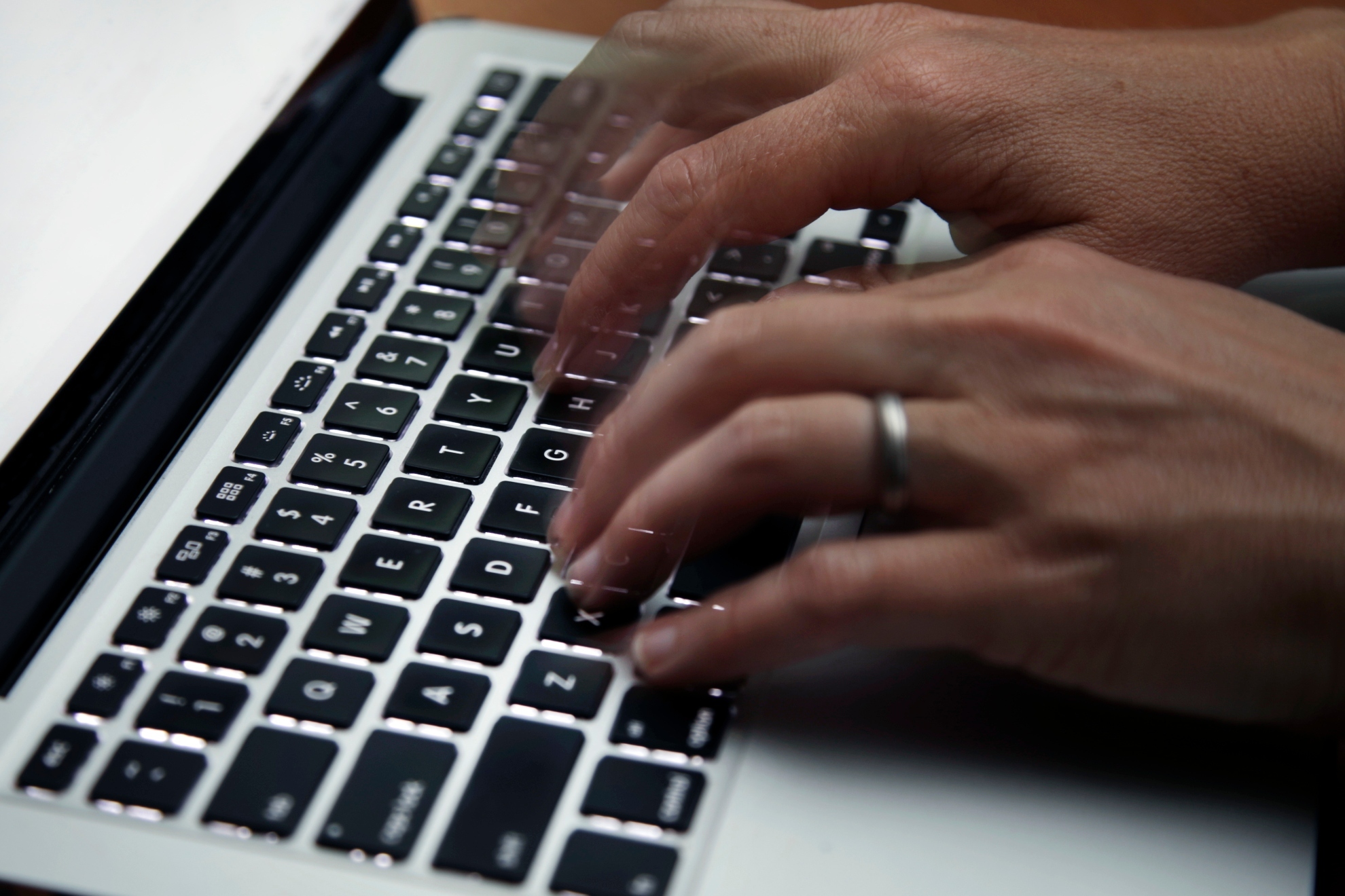 A pair of hands writing on a lap top