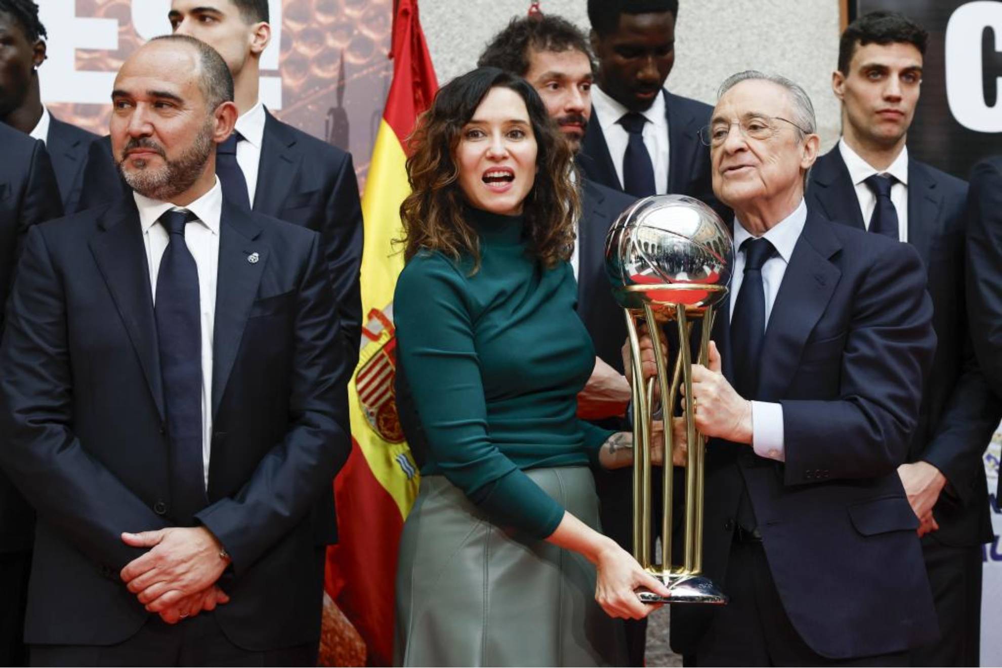 La presidenta de la Comunidad de Madrid, Isabel Daz Ayuso, sostiene el trofeo de Copa del Rey de baloncesto junto al presidente del Real Madrid Florentino Prez, y el entrenador blanco Chus Mateo.