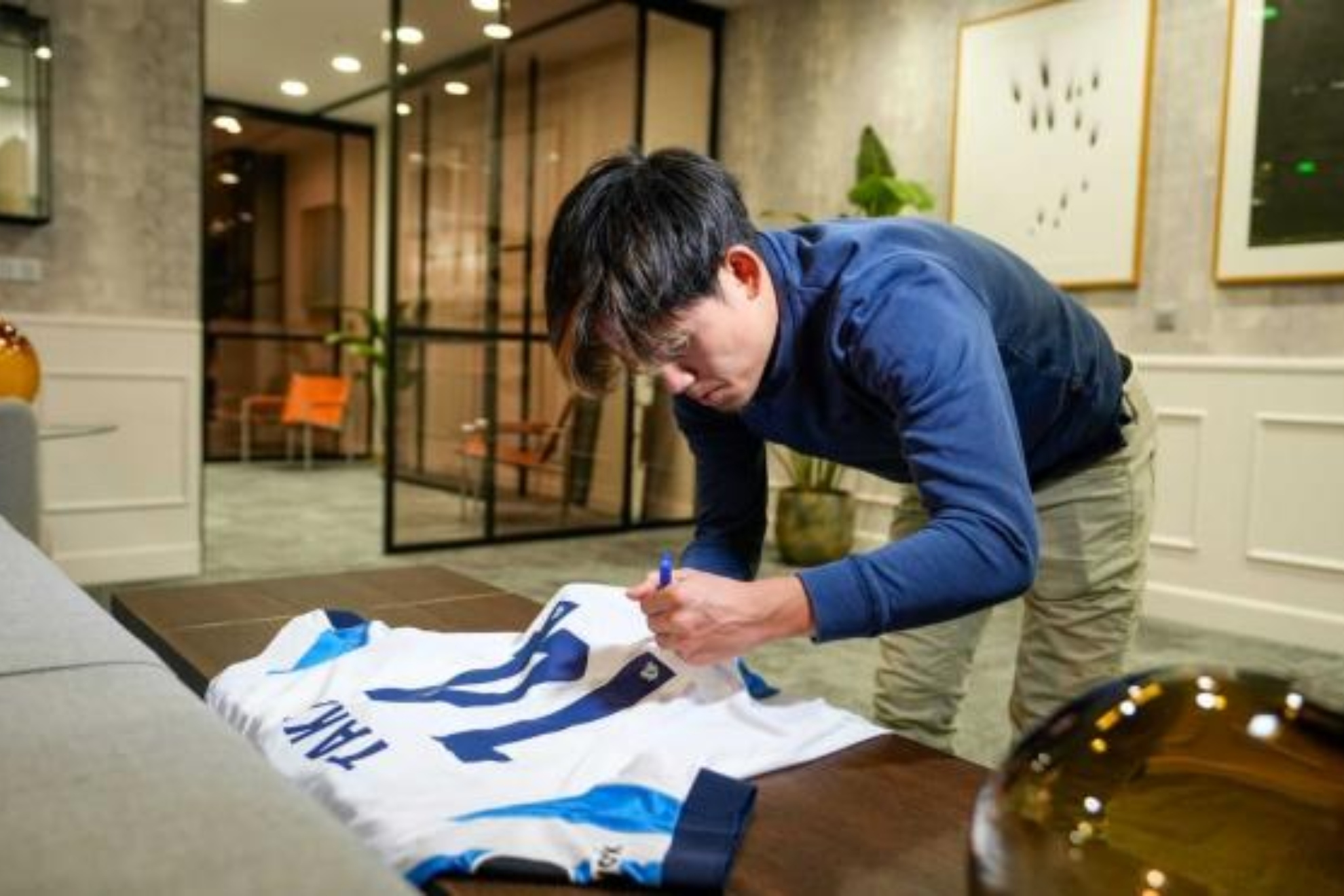 Take Kubo firma una camiseta suya, el día de su renovación.
