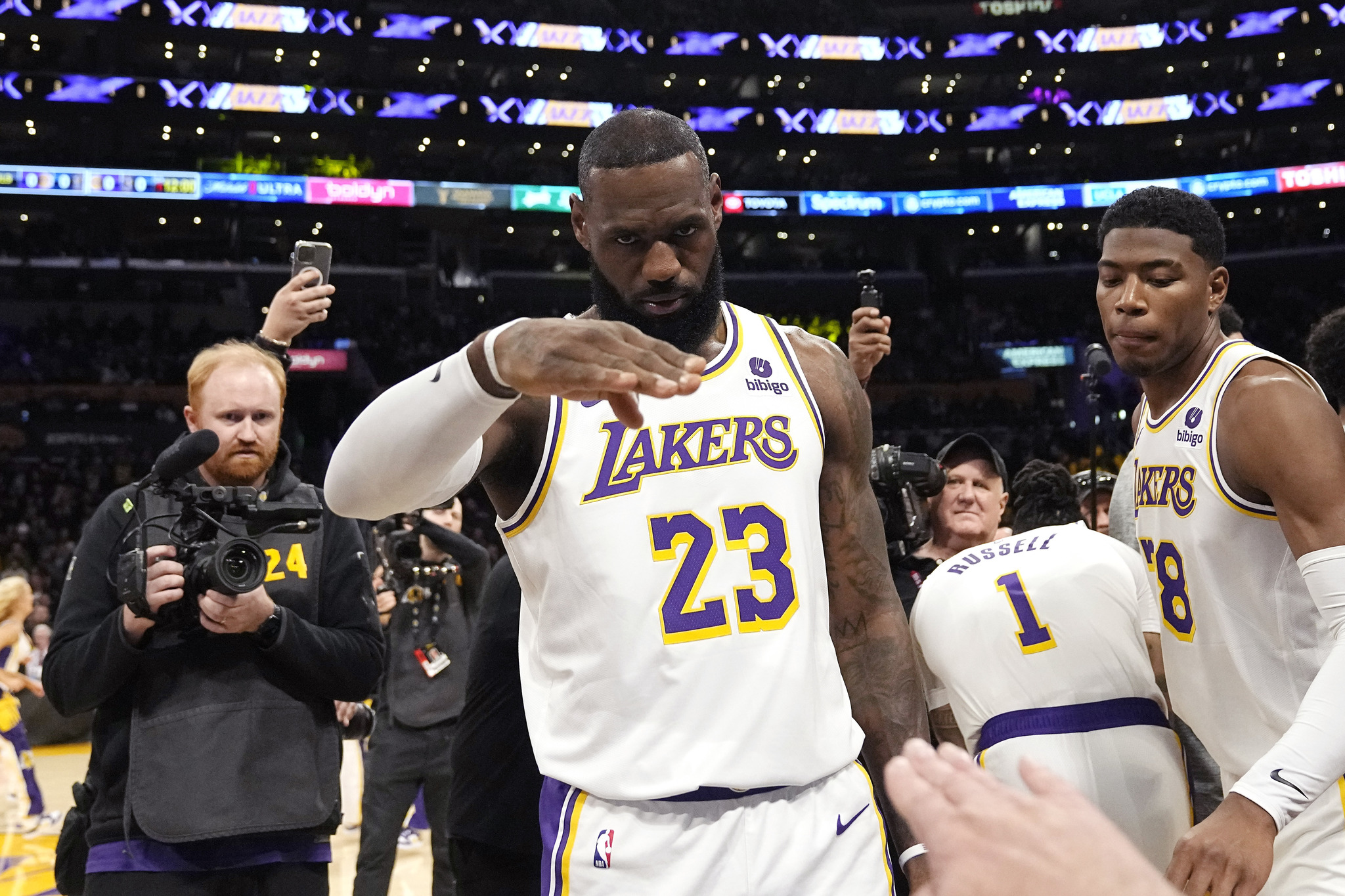 LA Lakers forward LeBron James salutes public address announcer Lawrence Tanter