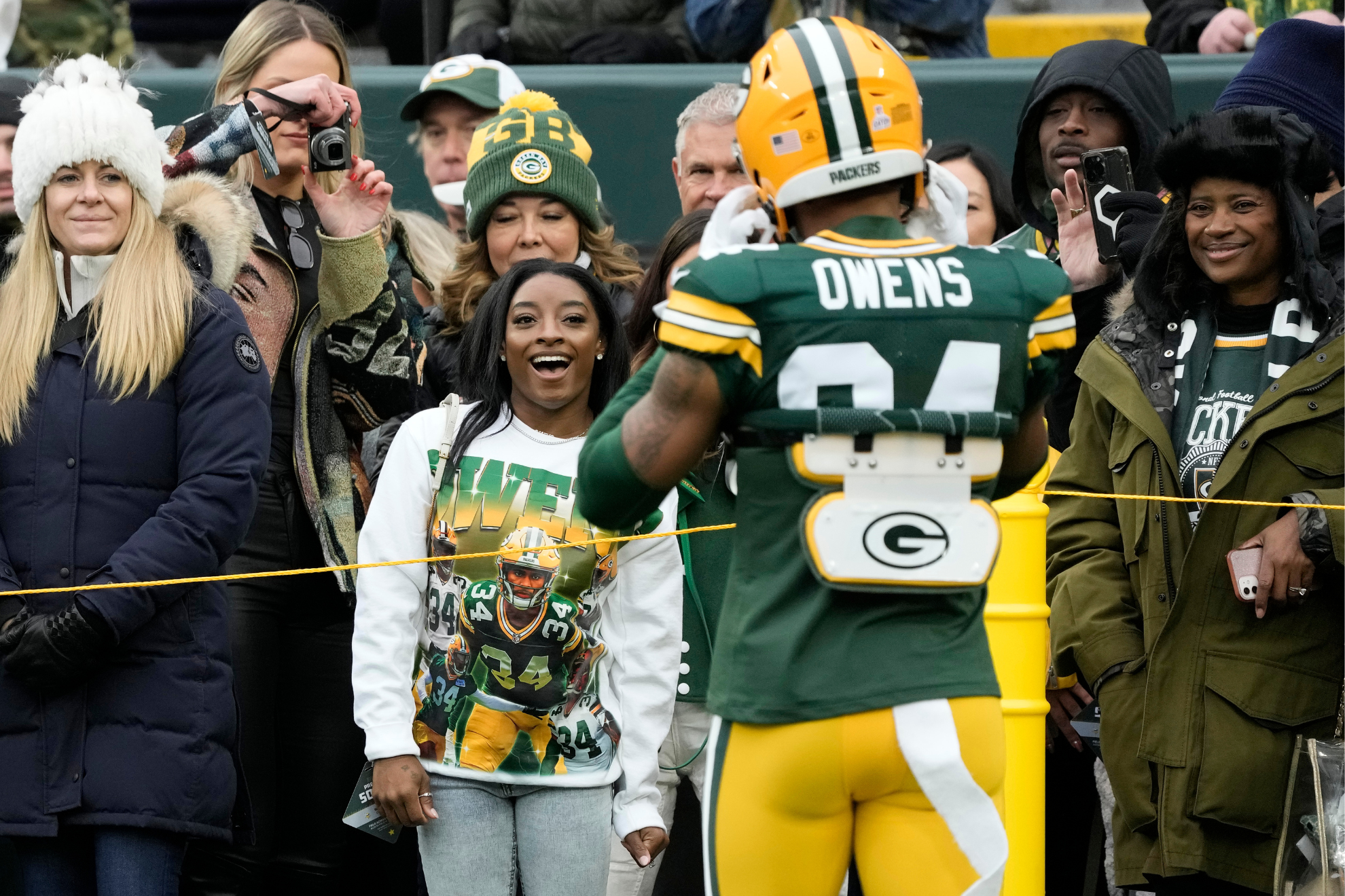 Simone Biles and Jonathan Owens during a Green Bay Packers game.