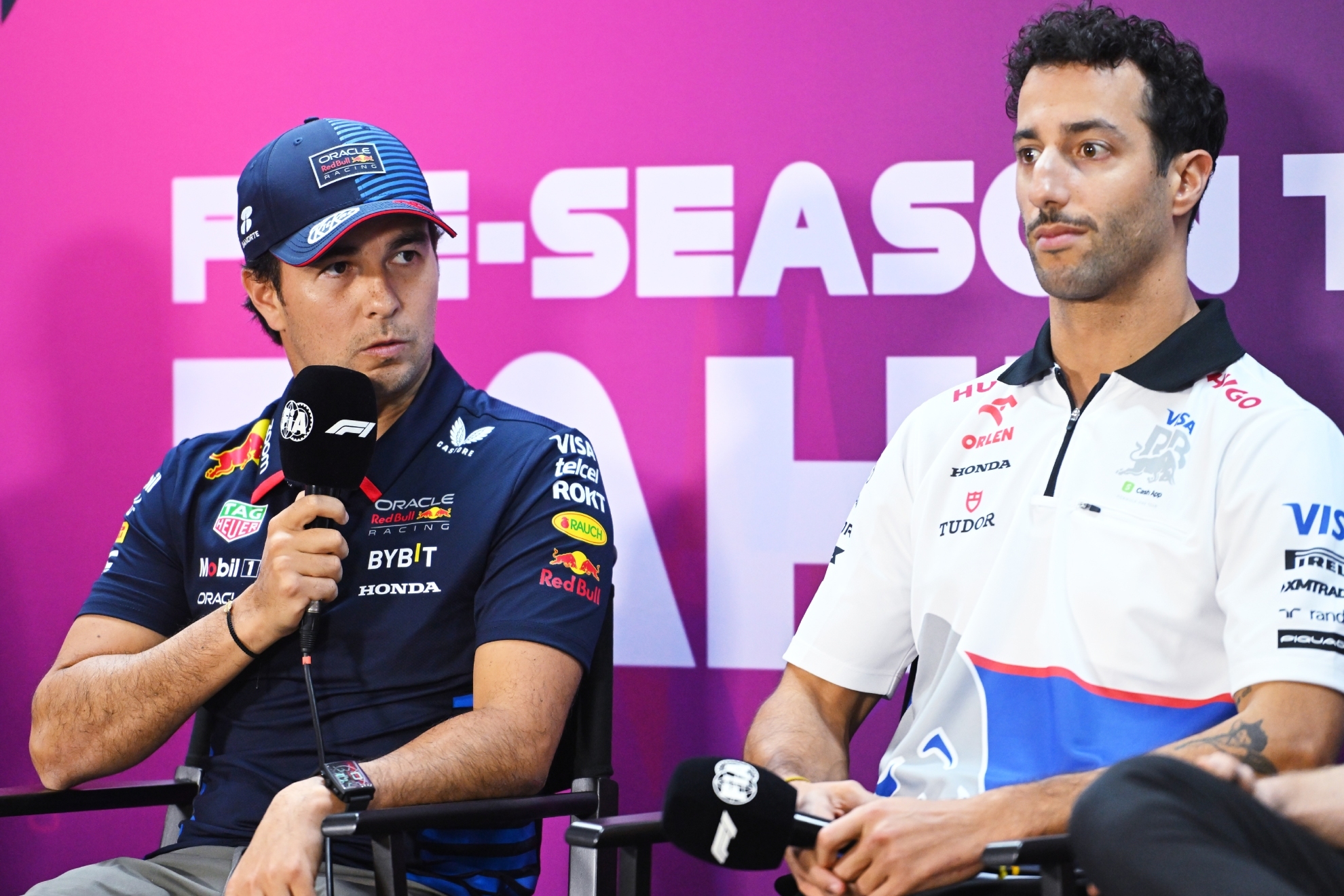 Checo Prez speaks at a press conference with Ricciardo beside him