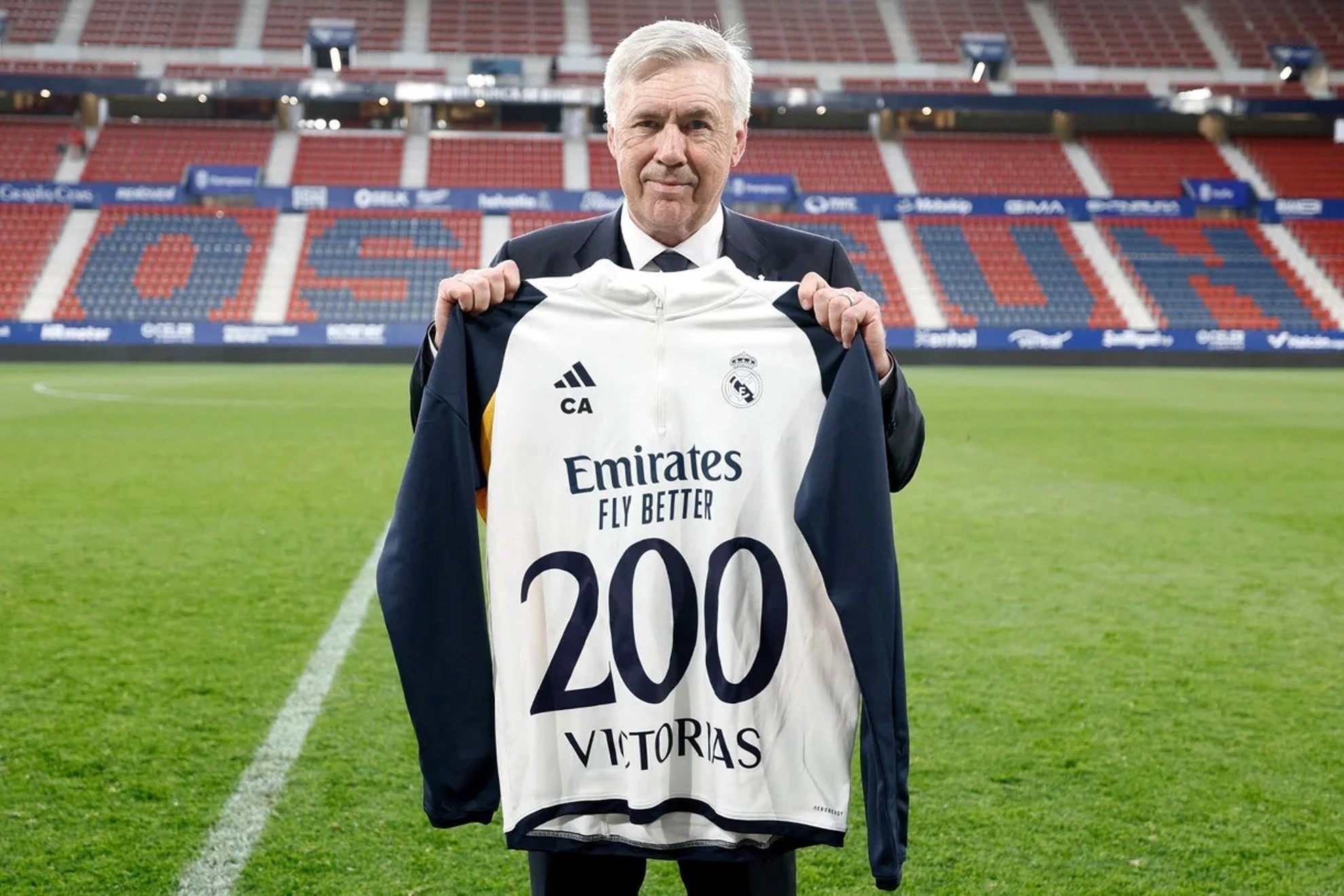 Carlo Ancelotti posa con uan camiseta conmemorativa en El Sadar