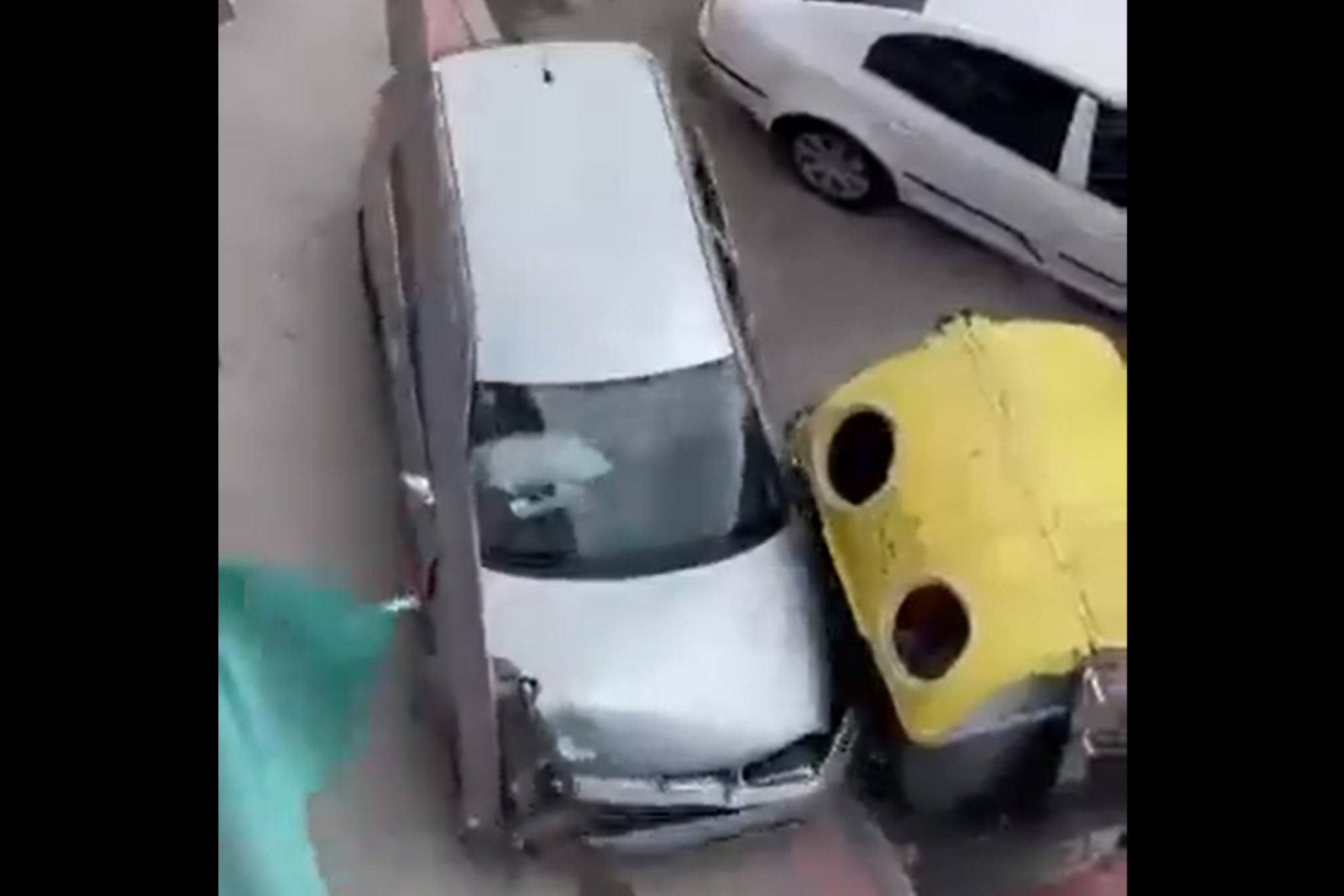 El conductor, tratando de huir por la acera entre una farola y un contenedor de basura