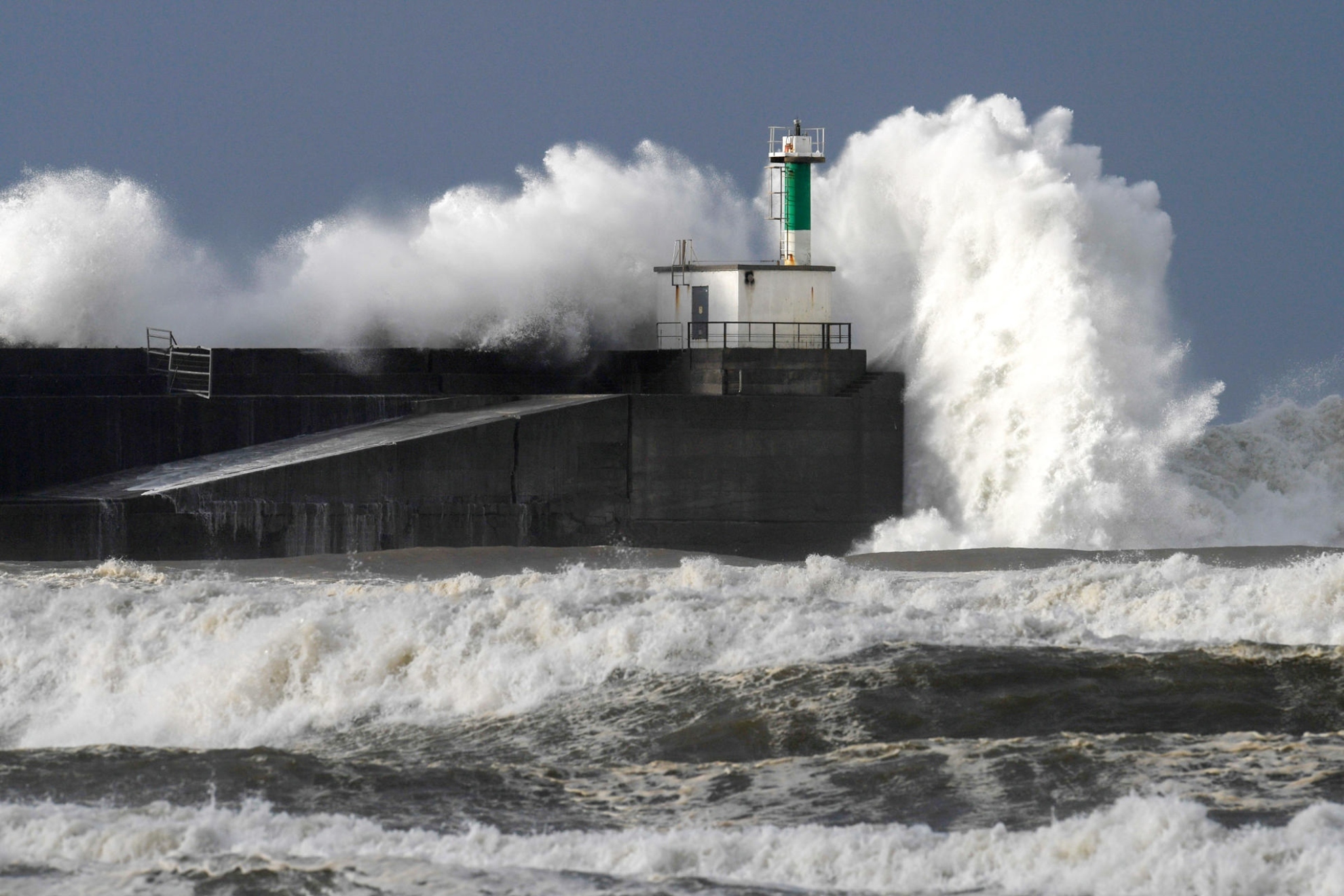 Una imagen de una ola rompiendo contra el faro del puerto de San Esteban de Pravia. EFE