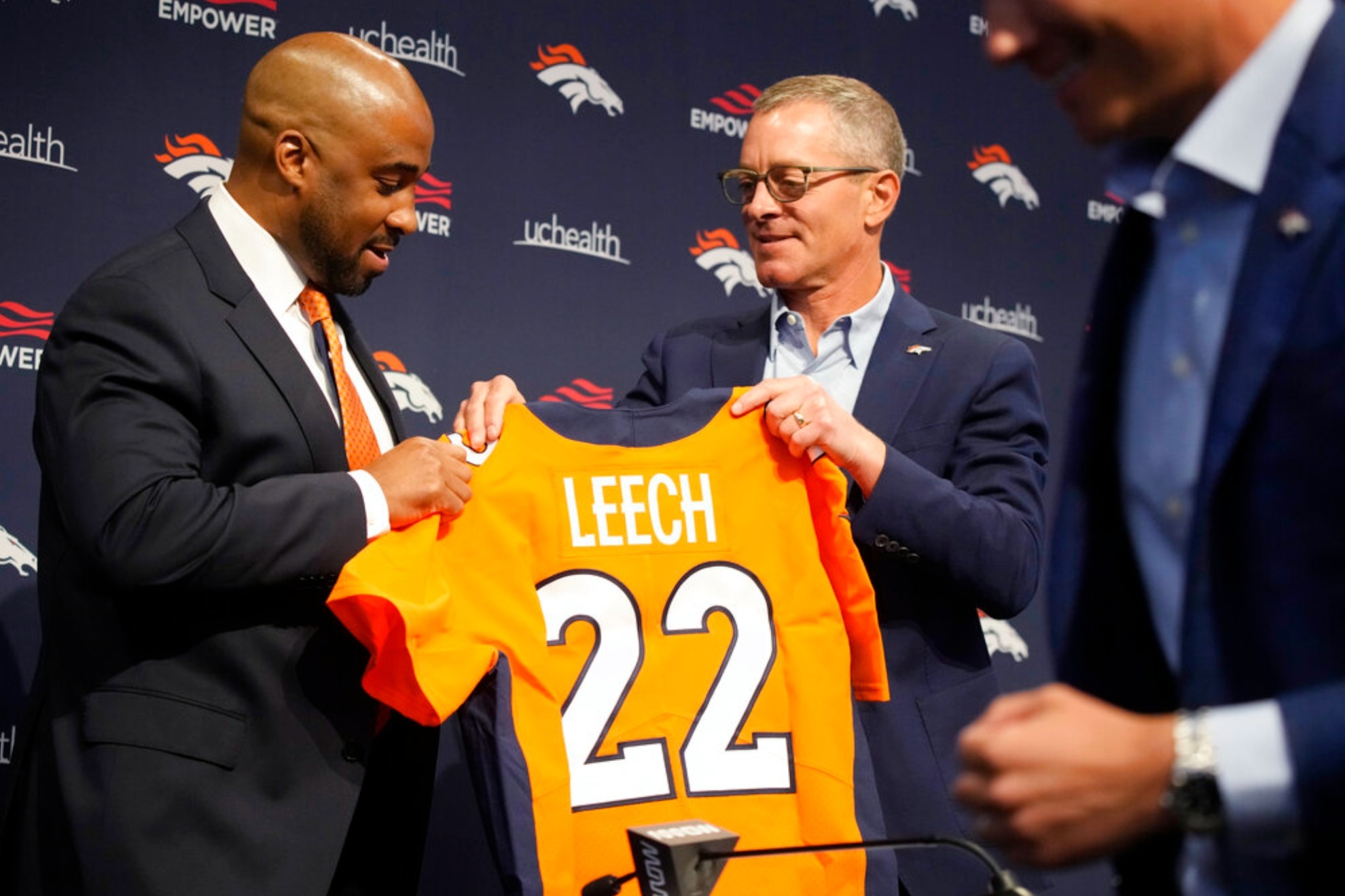 President Damani Leech (L) accepts a jersey from Greg Penner in 2022.