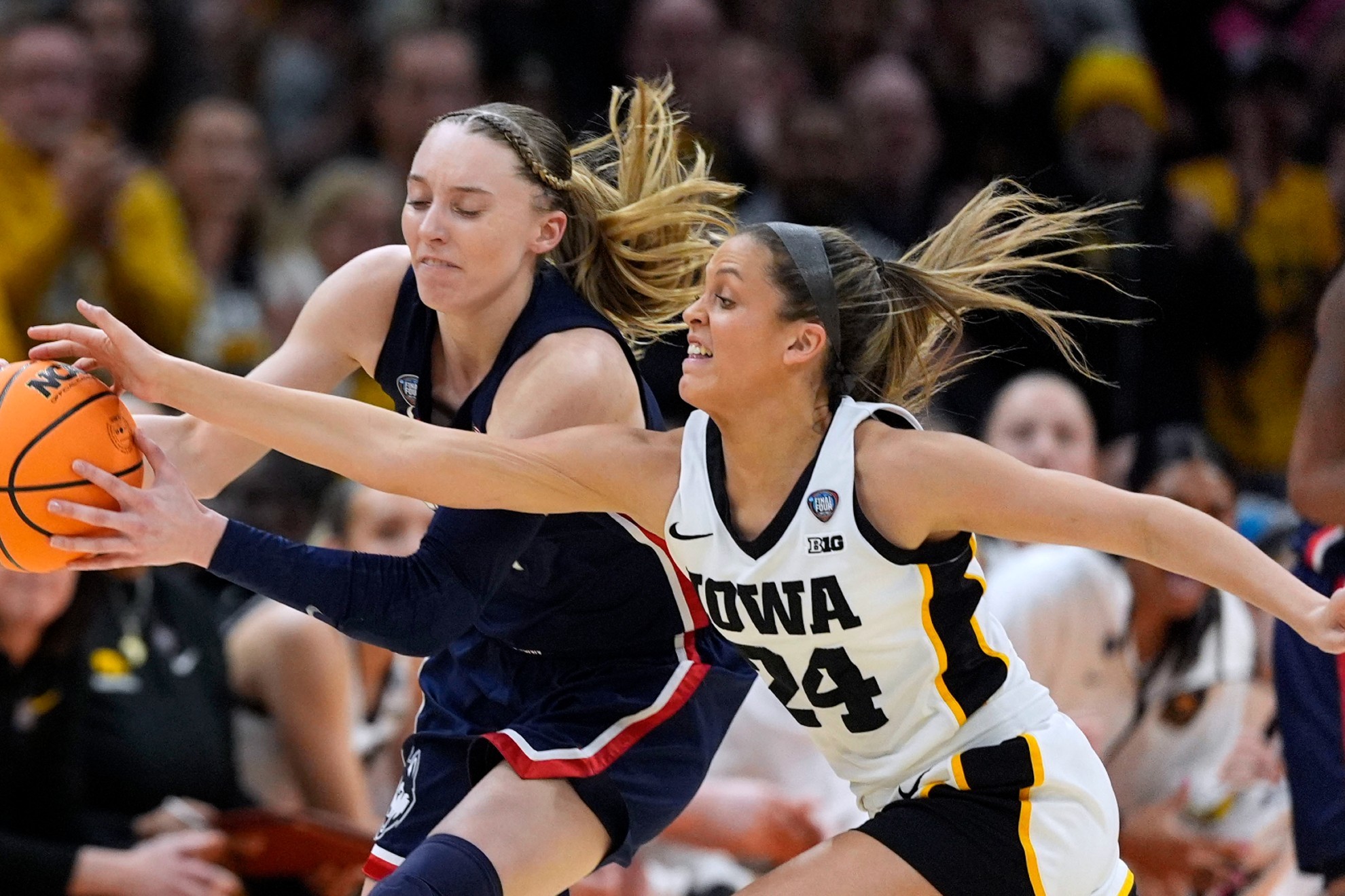 UConn guard Paige Bueckers, left, fights for a loose ball with Iowa guard Gabbie Marshall.