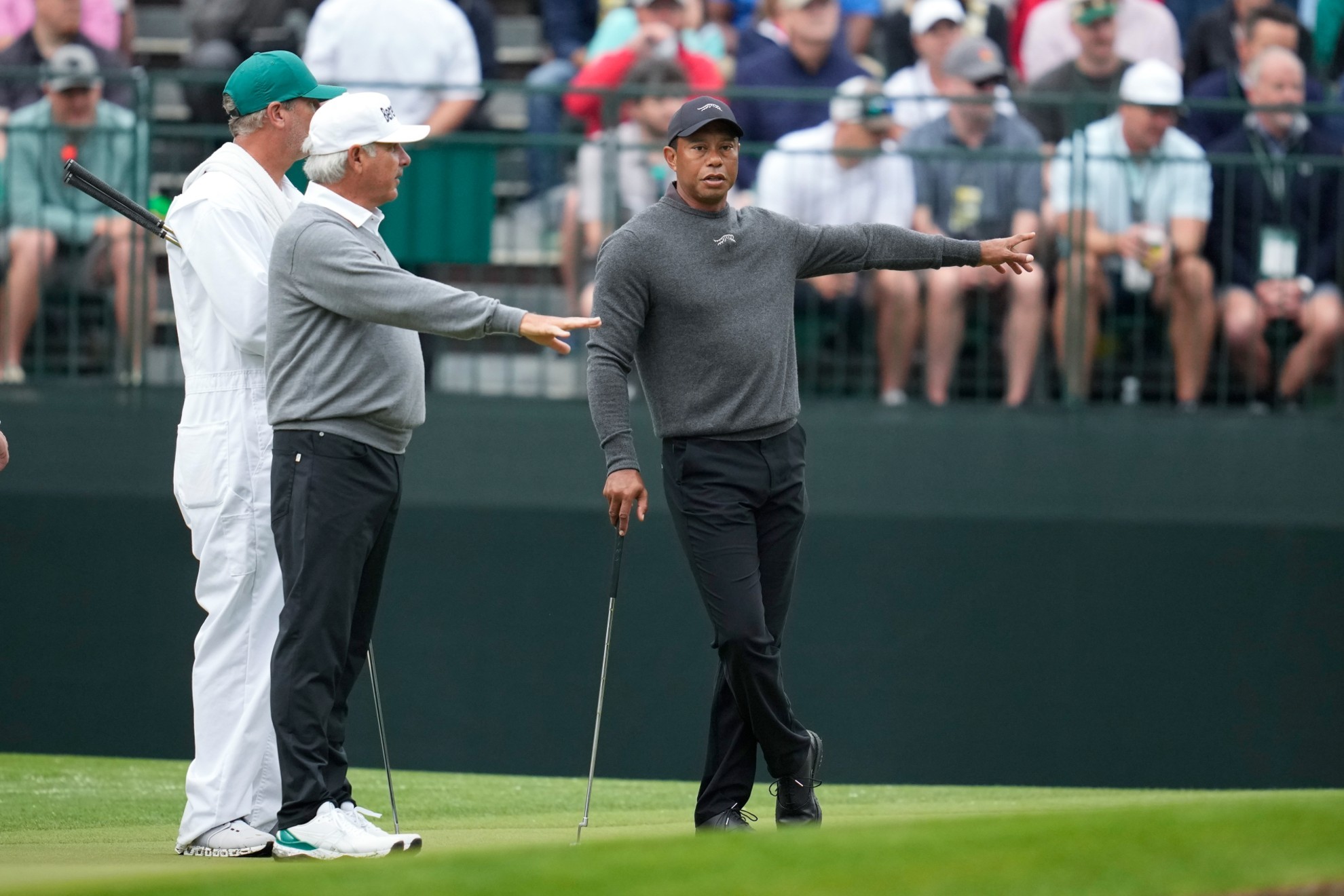 Tiger Woods, right, talks with Fred Couples on the fourth hole during a practice round in preparation for the Masters.