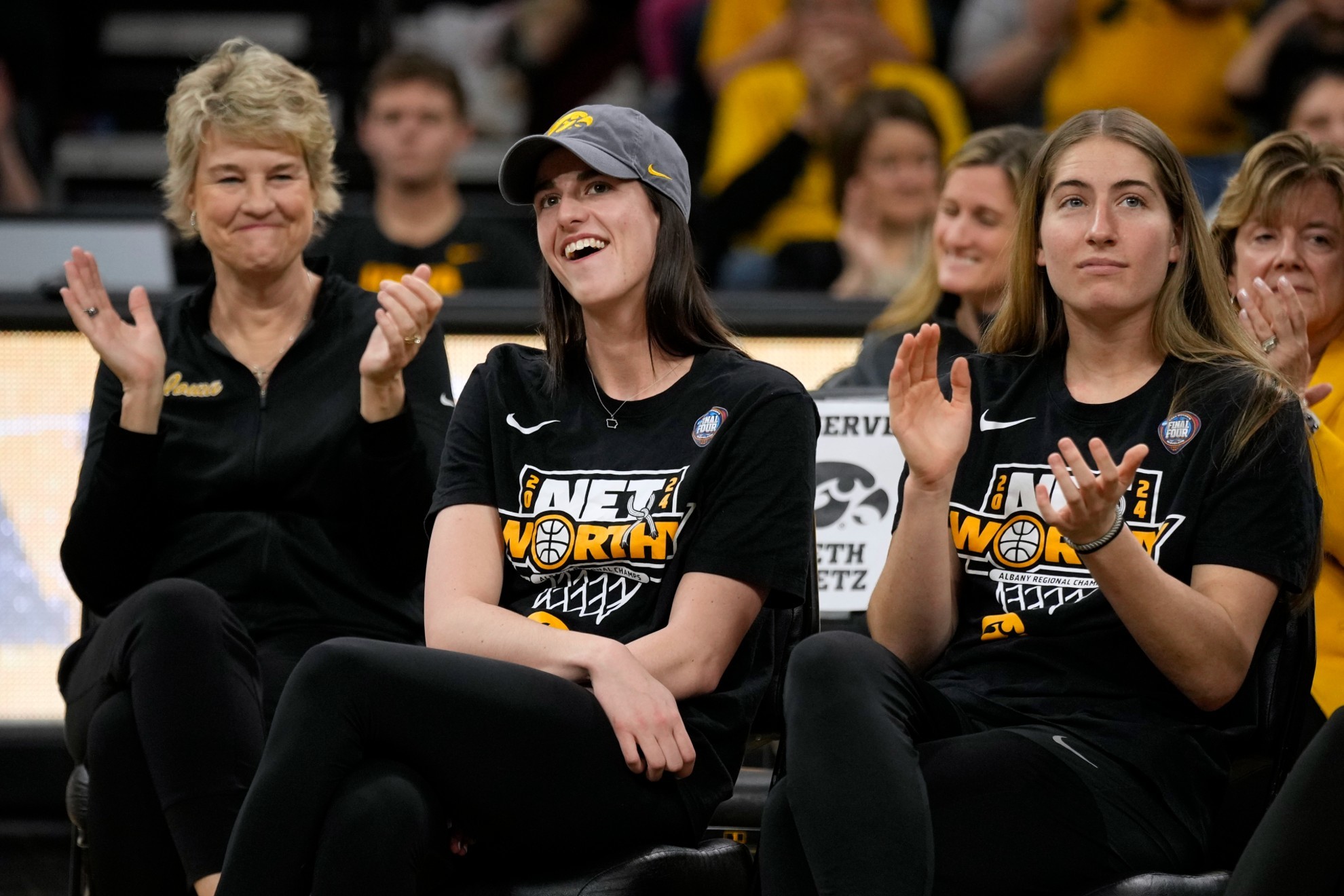 Iowa guard Caitlin Clark, center, sits with coach Lisa Bluder, left, and guard Kate Martin.