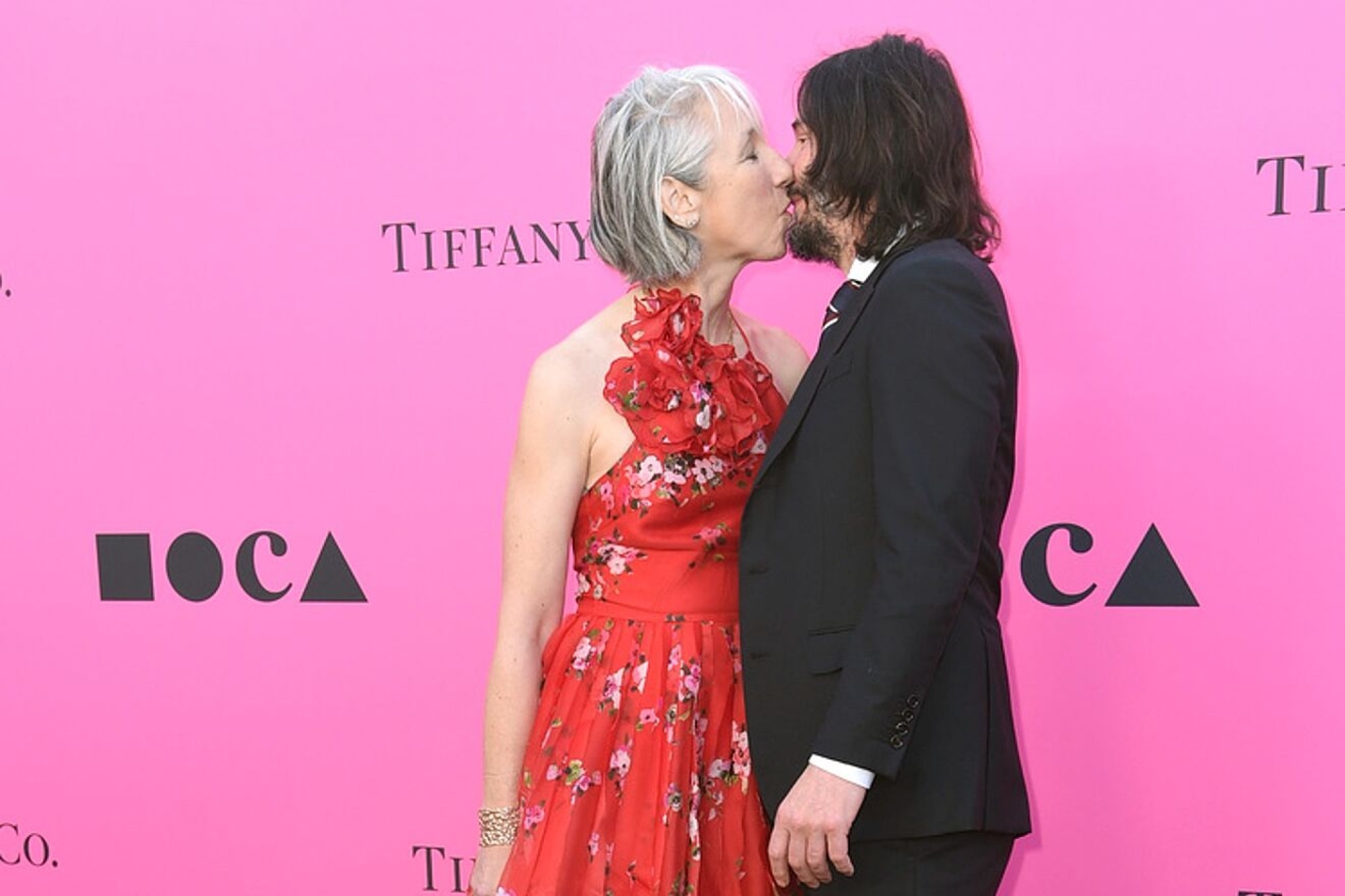 Keanu Reeves and his girlfriend give each other a tender kiss in public, but he... doesnt close his eyes