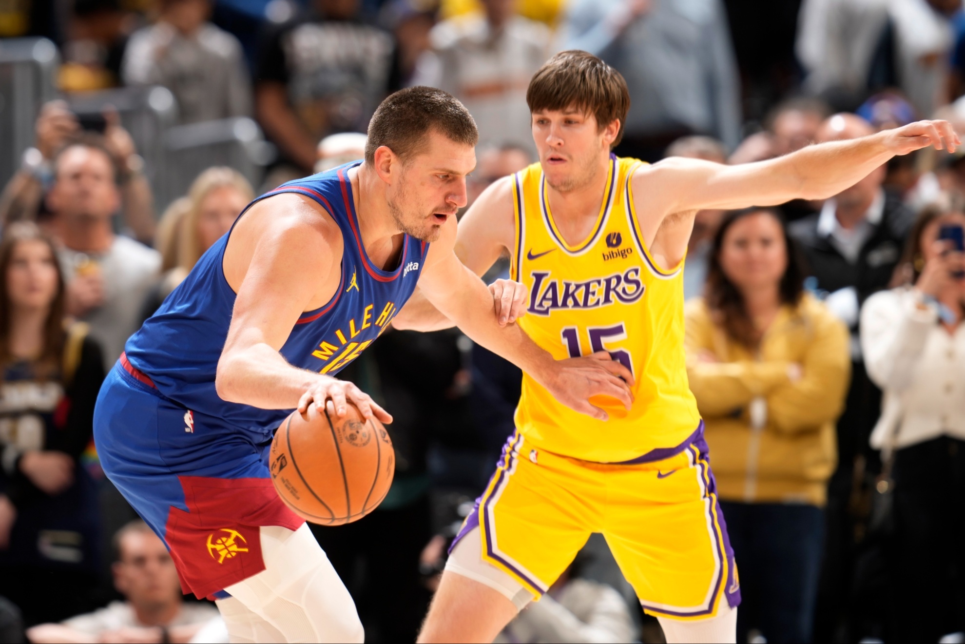 Denver Nuggets center Nikola Jokic (15) and Los Angeles Lakers guard Austin Reaves (15).