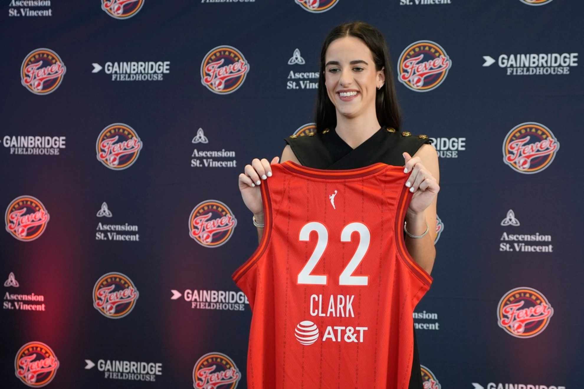 Caitlin Clark holds her jersey following a WNBA basketball news conference /