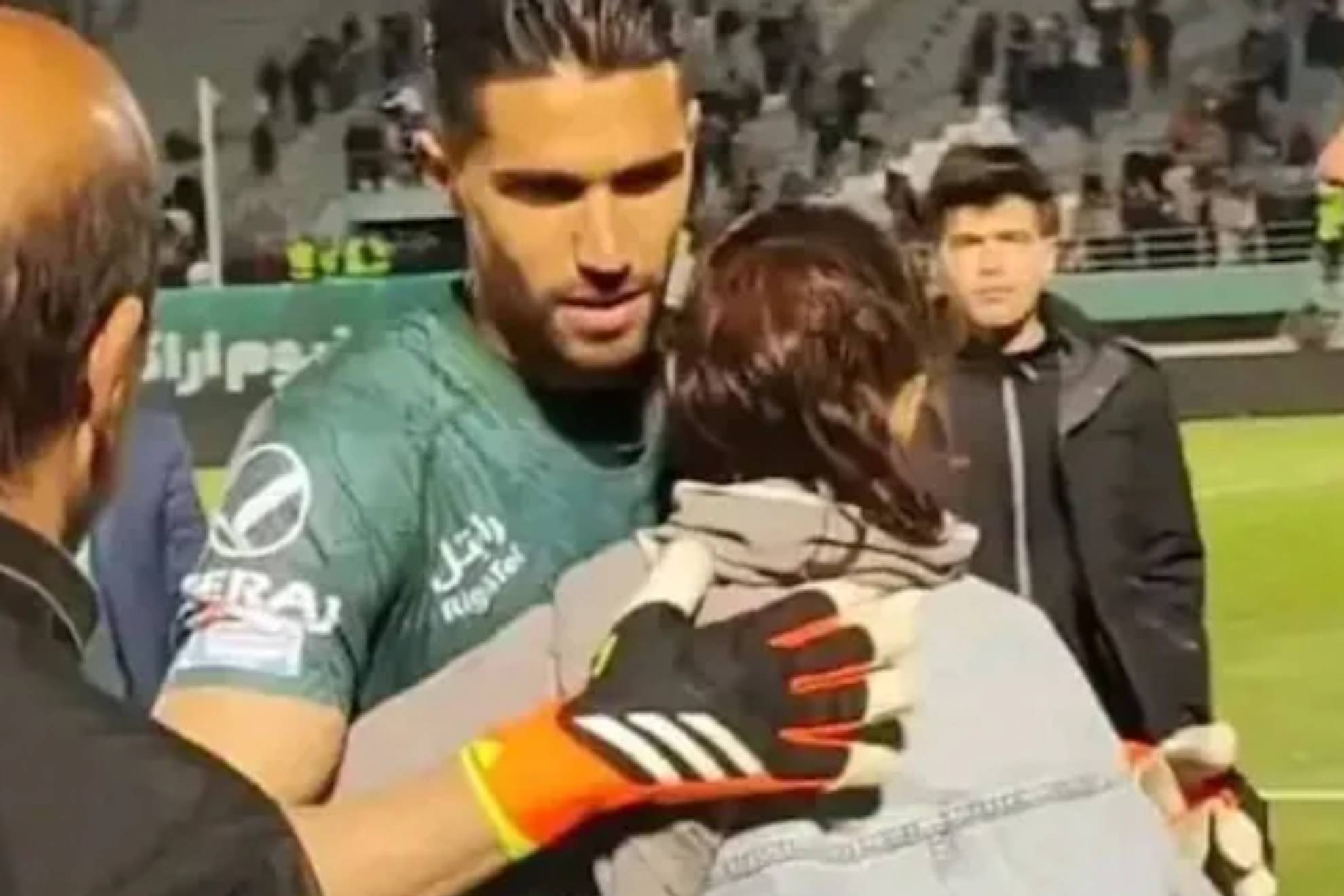 Iran suspends and fines its international goalkeeper after he hugged a woman at the end of a match
