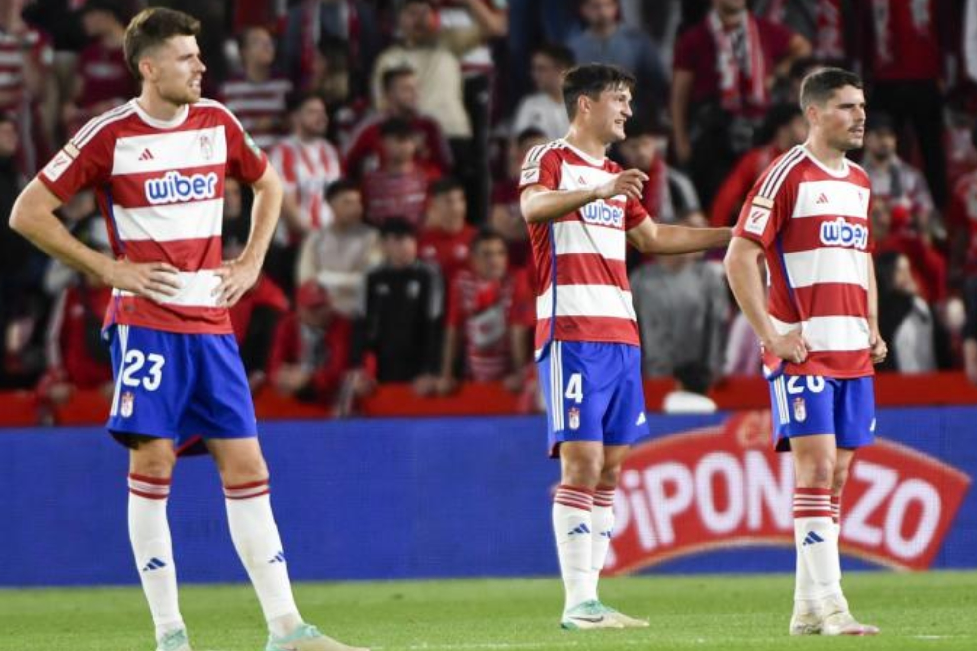 Los jugadores del Granada se lamentan tras recibir un gol.