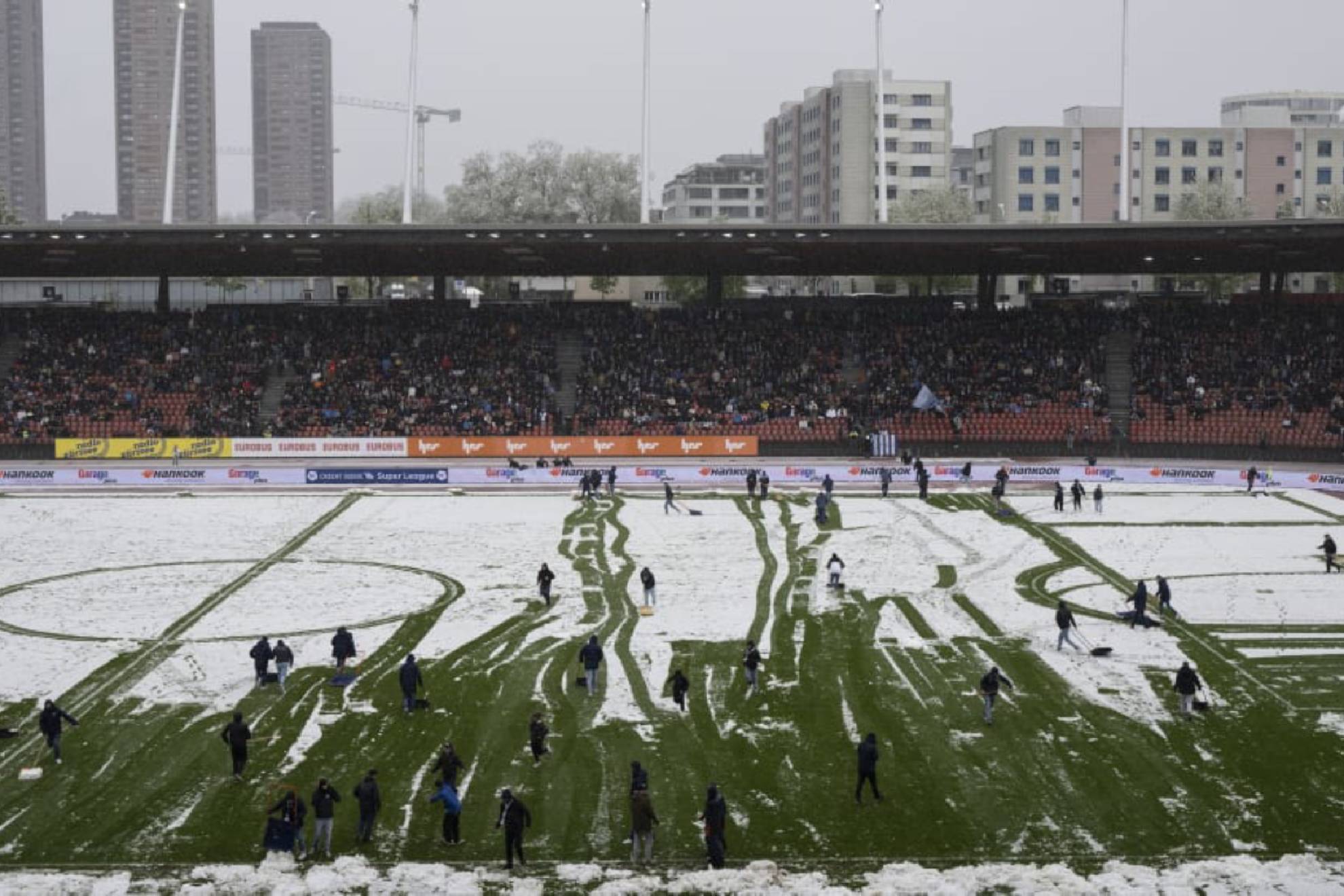 Aficionados del Zrich saltan al campo a quitar la nieve... para que el partido pudiera continuar!