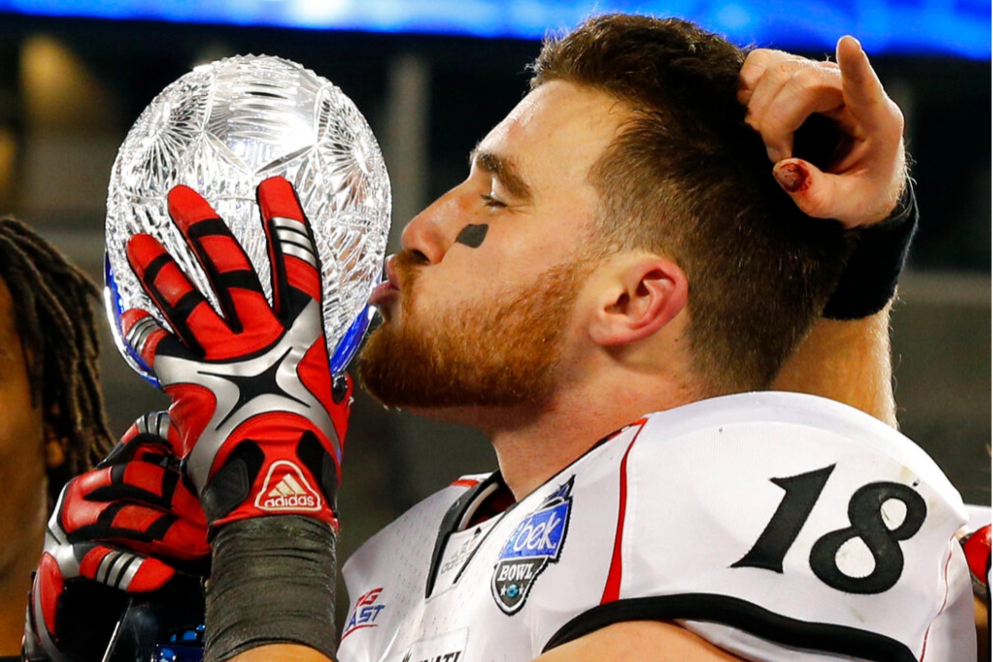 Travis Kelce kisses the trophy after Cincinnati defeated Duke in the Belk Bowl in 2012.