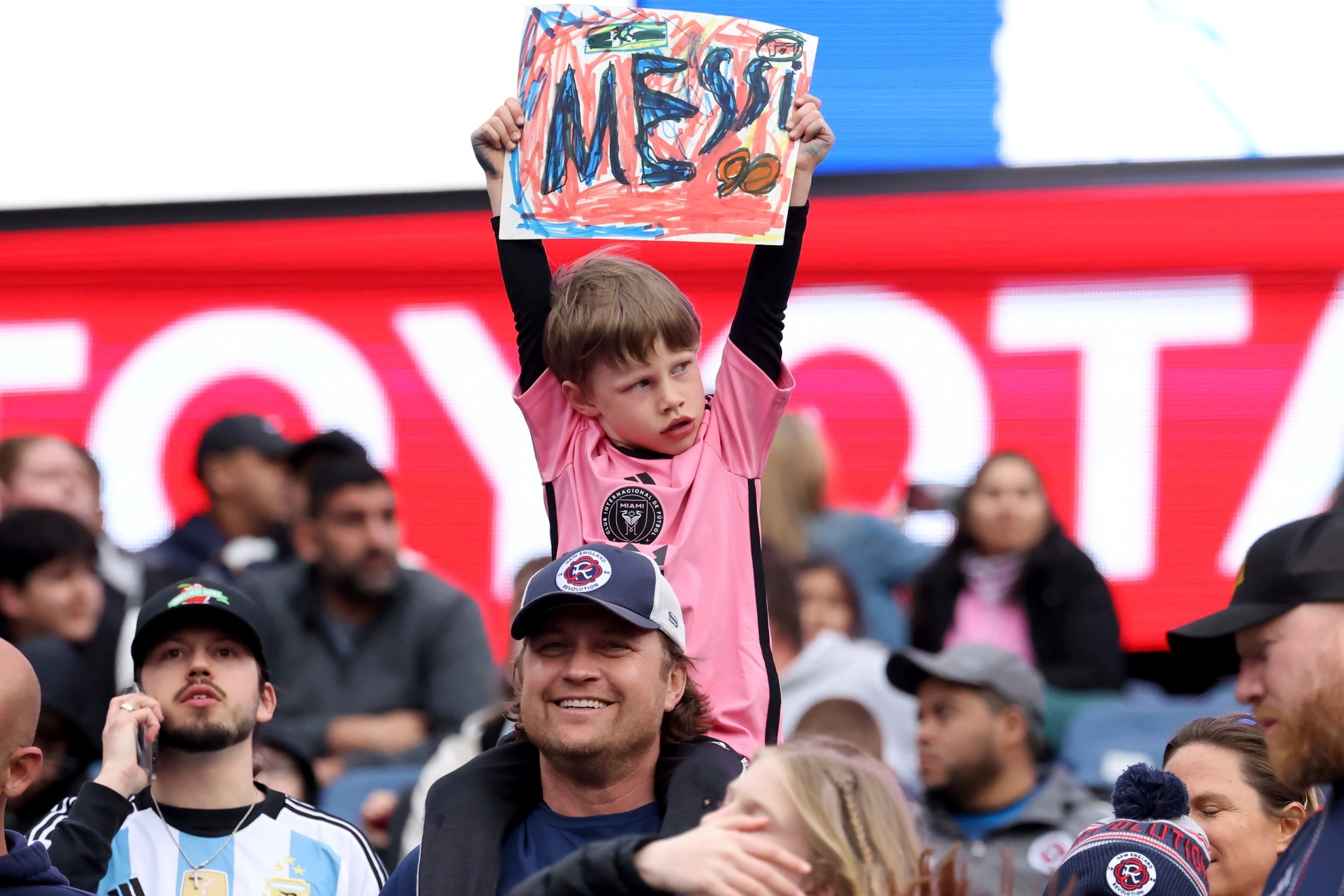 A young fan shows his support for Inter Miami forward Lionel Messi before an MLS soccer match against the New England Revolution