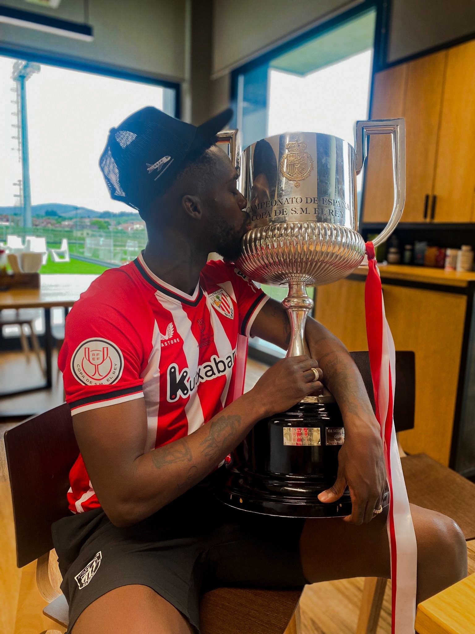 Iaki Williams besa la Copa con la gorra que ahora ha sacado a la venta.