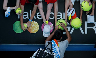 Djokovic firma autgrafos a los aficionados del Open de Australia tras su partido de primera ronda.