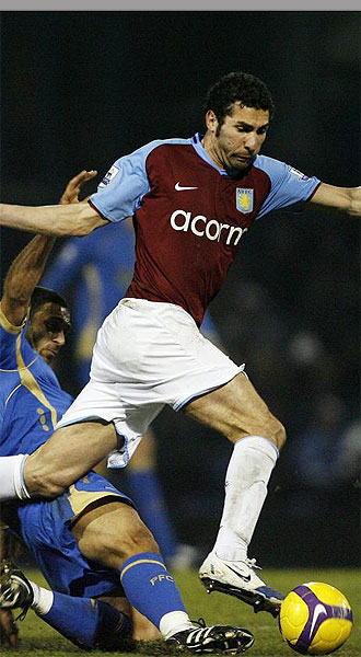 Carlos Cuéllar, jugador del Aston Villa, disputa un balón con un jugador del Portsmouth