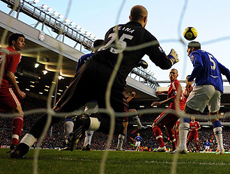 El meta del Liverpool, Pepe Reina, intenta detener un remate del Everton.