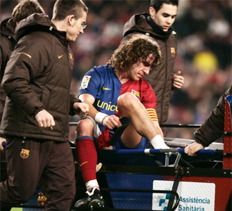 Carles Puyol es retirado en coche del terreno de juego.