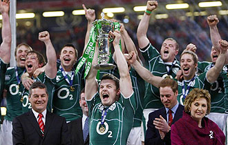 El capitán Brian O'Driscoll levanta el trofeo que acredita a Irlanda como campeona del Torneo VI Naciones en presencia del Príncipe Guillermo y de Mary Mcaleese, la presidenta irlandesa