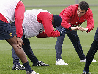 Cesc realiza estiramientos en el entrenamiento del Arsenal.