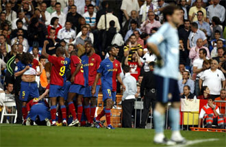 Los jugadores del Barcelona, en segundo plano, celebran un tanto mientras Casillas, a la derecha, se lamenta.