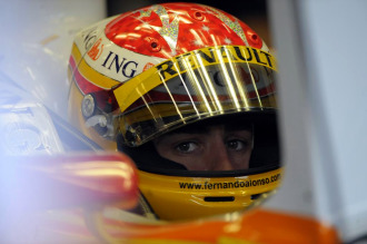 Fernando Alonso, sobre su monoplaza en el 'box' de Renault.
