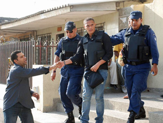 Javier Flrez sale de la Fiscala con un chaleco antibalas rodeado de policas.