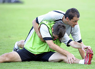 Josu Iglesias realiza ejercicios de estiramiento junto a Gurrutxaga durante un entrenamiento del Real Unin