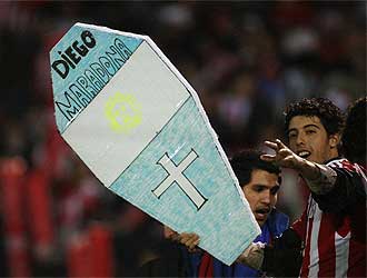 Un aficionado paraguayo con una lpida de cartn dedicada a Maradona.
