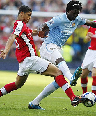 Adebayor pugna por un baln con Denilson durante el partido ante el Arsenal