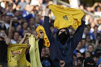 Aficionados del Schalke 04 provocan a la hinchada del Borussia Dortmund exhibiendo banderas y camisetas de este equipo en el partido que enfrent a ambos conjuntos.