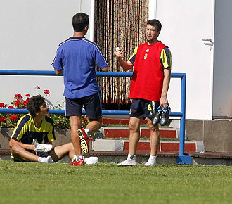 Josico charla con un tcnico y un compaero, con las botas en la mano, durante un entrenamiento de Las Palmas de esta temporada