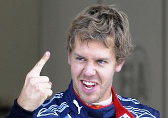 Vettel levanta el dedo índice para indicar que es el primero.