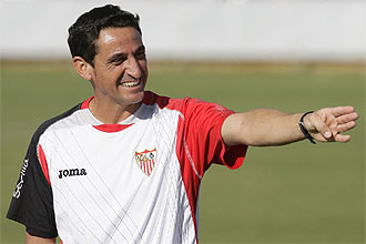 Manolo Jiménez sonríe mientras da indicaciones a sus jugadores en un entrenamiento del Sevilla.