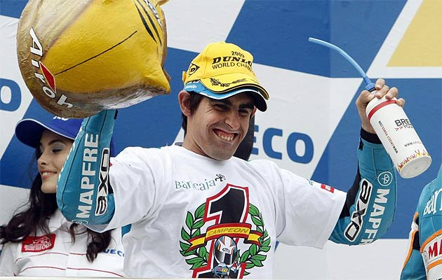 Simn celebra en el podio con una camiseta conmemorativa su ttulo de 125cc.