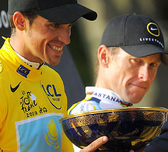 Contador recibe su trofeo de ganador del Tour ante la atenta mirada de Armstrong