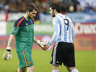Casillas choca la mano con su compaero Higuan