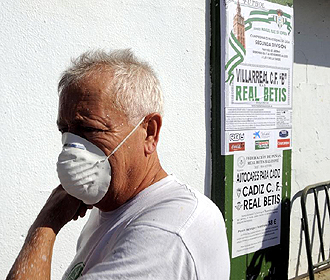 Un empleado del Betis, con la mscara protectora por la epidemia de gripe A, pasa delante del cartel del encuentro que deban haber disputado verdiblancos y Villarreal B el pasado 1 de noviembre