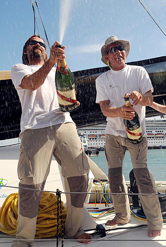 Javier Sans celebra junto a su compaero Mike Golding, botella de cava incluida, en Puerto Limon el tercer puesto logrado en la Transat Jacques Brave