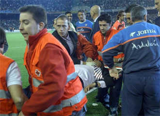 Juande Ramos es trasladado en camilla tras sufrir un botellazo en el Ruiz de Lopera