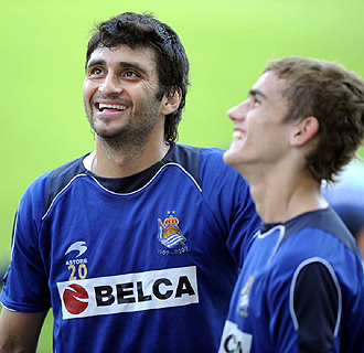 Carlos Bueno sonre junto a Griezmann durante un entrenamiento de la Real Sociedad