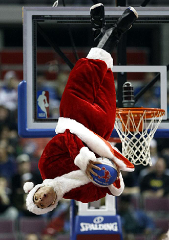 Un miembro del 'Flight Crew', el equipo de ma de los Pistons, hace un espectacular mate con el traje de Santa Claus en el partido ante los Raptors en Auburn Hills