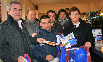 Jugadores y directivos de la Segoviana posan con un pincho, el cartel del certamen y la camiseta del equipo.