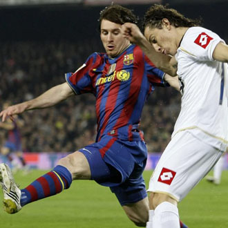 Guardado intenta superar la oposicin de Leo Messi