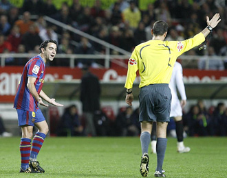 Xavi protesta al rbitro una decisin en el partido contra el Sevilla