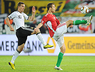 Podolski, autor del primer gol alemn, pugna por la pelota con un jugador hngaro